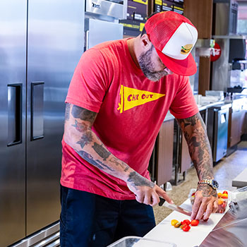 Learn about True® Refrigeration and our 赛车168(中国福彩)一分钟历史开奖号码结果体彩网 for Fast Casual - Person Cutting Food on Cutting Board